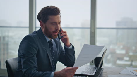 closeup happy businessman calling mobile phone at cityscape office. boss talking