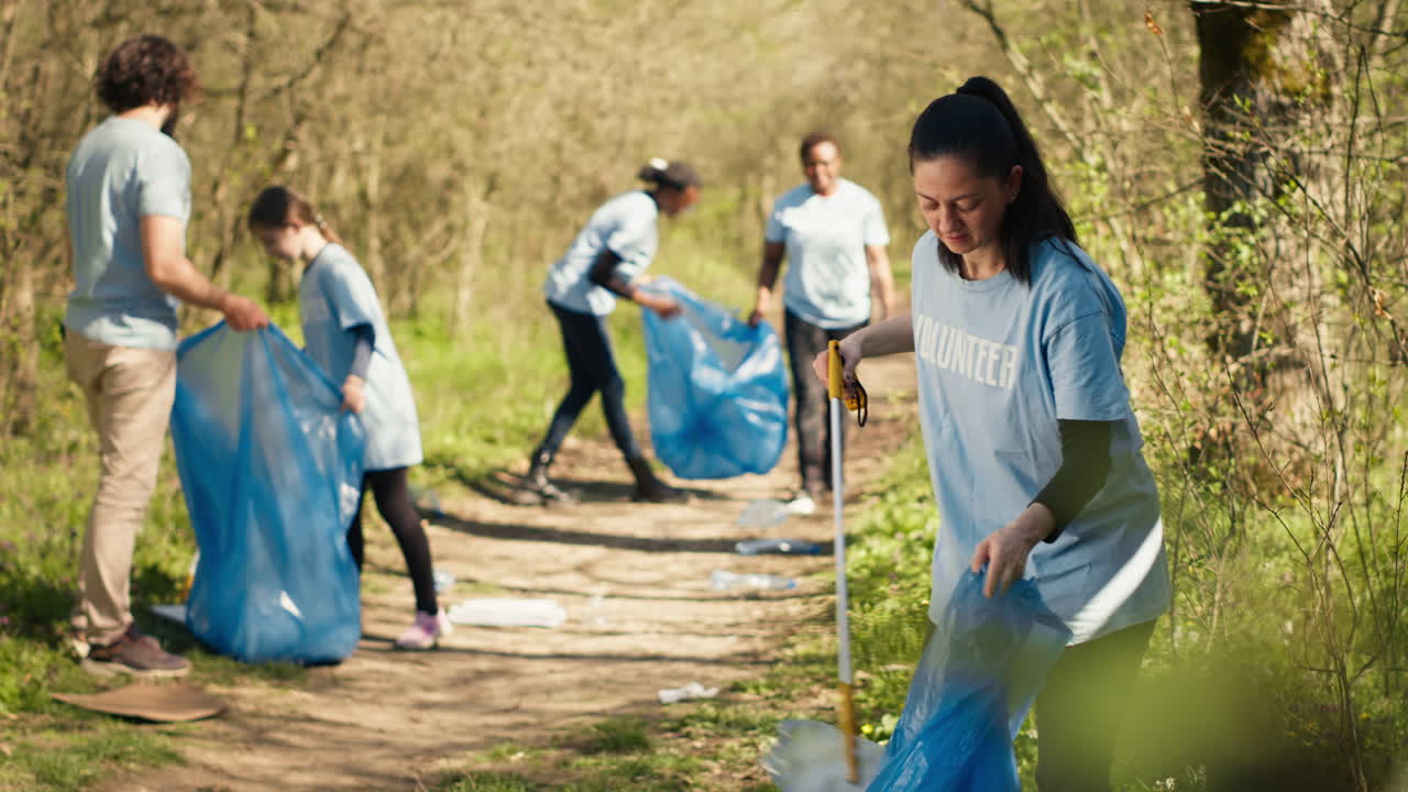 Environmental activist picking up trash with a claw tool and recycling