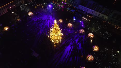 People-enjoy-beauty-of-Kaunas-Christmas-tree-and-market,-aerial-drone-view