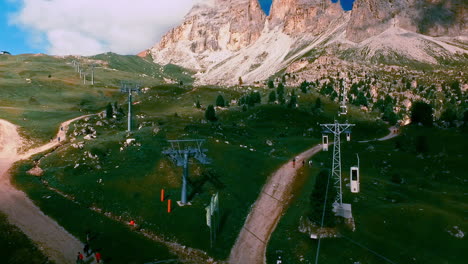 The-Langkofel-cable-car-brings-hikers-and-climbers-on-the-summit-of-the-mountain,-while-other-tourists-stroll-toward-the-city-of-stone-