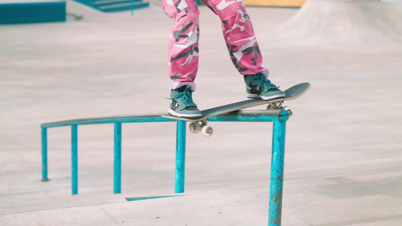 Skateboarder Performing a Rail Grind Trick in a Concrete Skatepark