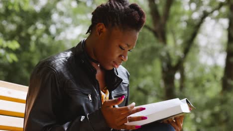 woman reading a book in a park