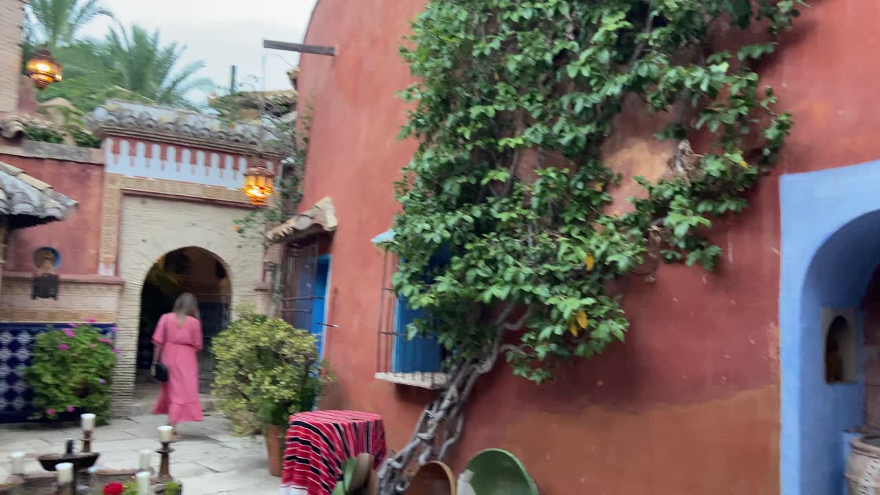 Young blonde hair woman walking through the typical full decored Arab courtyard of a mosque museum.