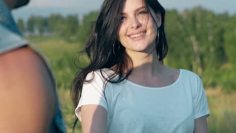 close view smiling brunette girl walks holding man hand