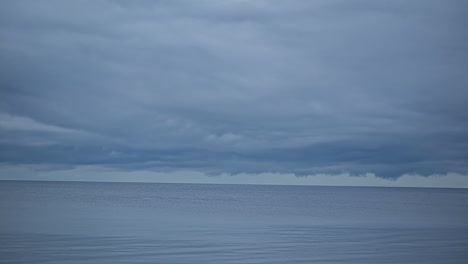 timelapse shot of movement of thick clouds over blue sea water along shoreline at daytime