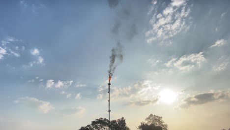 establisher wide view of single burning flare stack flame releasing co2