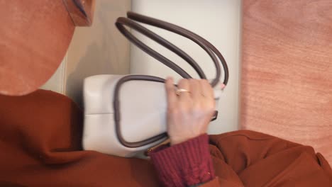 Woman holding a beige handbag