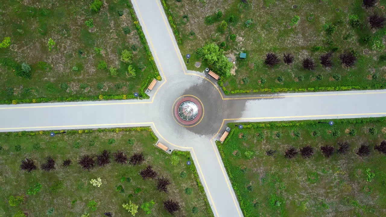 Paths in the park with fountain in the middle and four benches. Top view on the landscape design of a green city area.