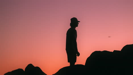 silhouette of a man looking off into the sunset