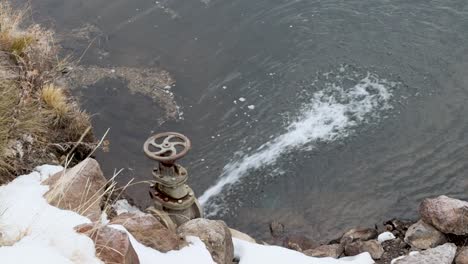 Öffnen-Sie-Den-Absperrschieber,-Der-Einen-Teich-Mit-Schnee-Füllt,-Der-In-Der-Nähe-Schmilzt