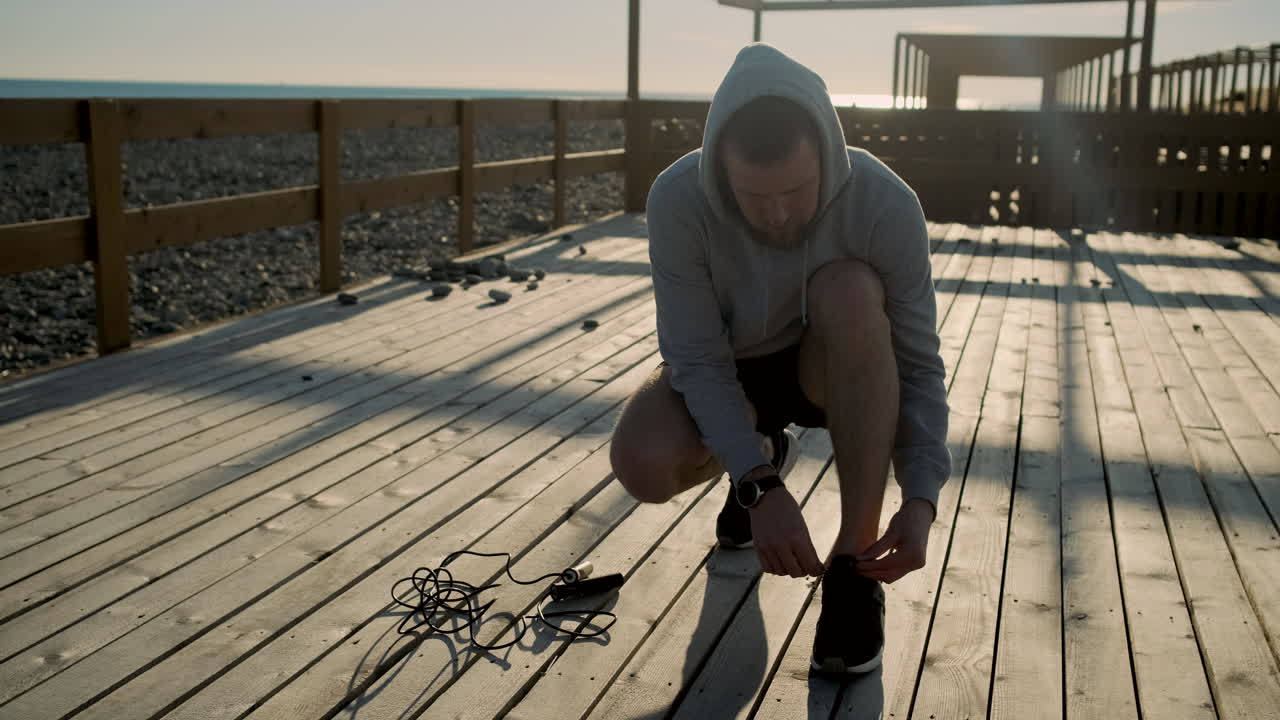 Man getting ready for a run on a beach pier