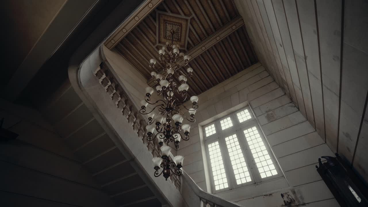 Elegant Chandelier and Sweeping Staircase in Abandoned Mansion