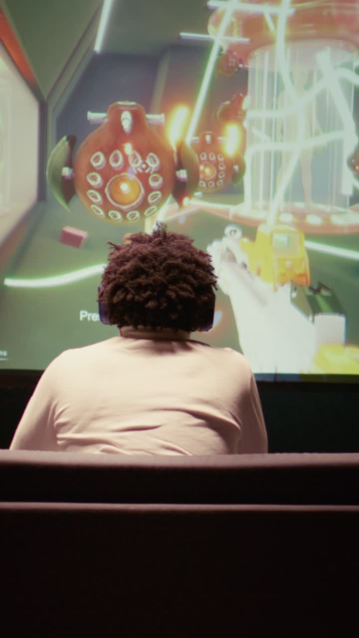 Vertical video Man watching gameplay footage of videogame competition on gigantic smart TV