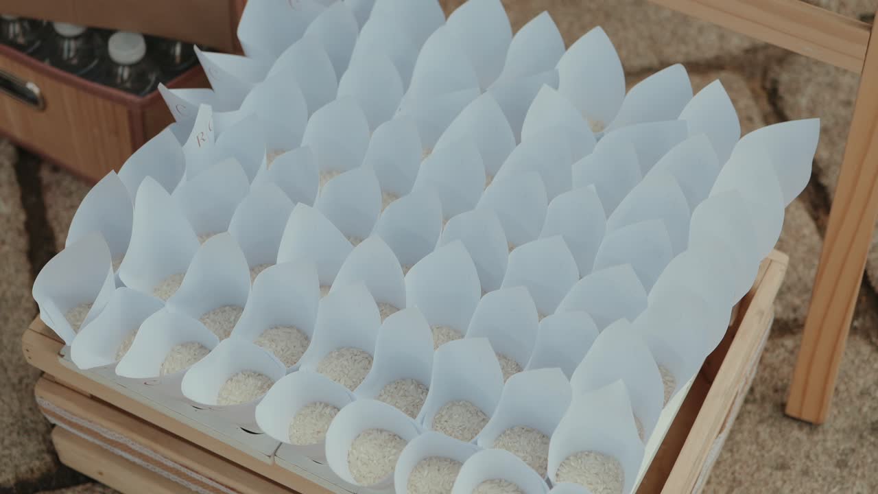 Conos de papel blancos rellenos de arroz preparados para una boda