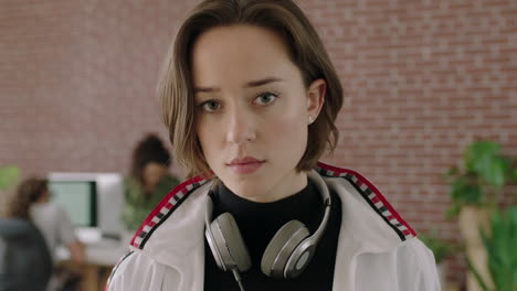 portrait of stylish young caucasian woman looking serious pensive at camera running hand through hair in contemporary internet cafe workspace