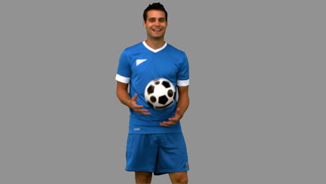 hombre haciendo malabarismos con un fútbol en la pantalla gris