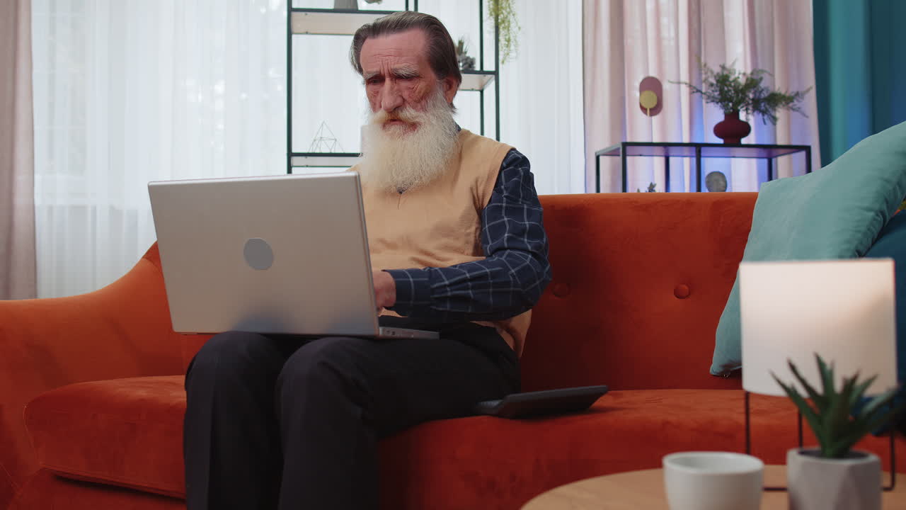 Smiling happy man counting money cash and use laptop pc calculate domestic income earnings at home