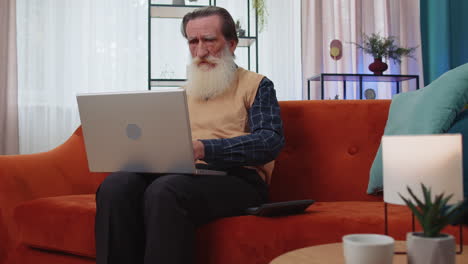 hombre feliz sonriente contando dinero en efectivo y usar computadora portátil calcular los ingresos domésticos ganancias en casa