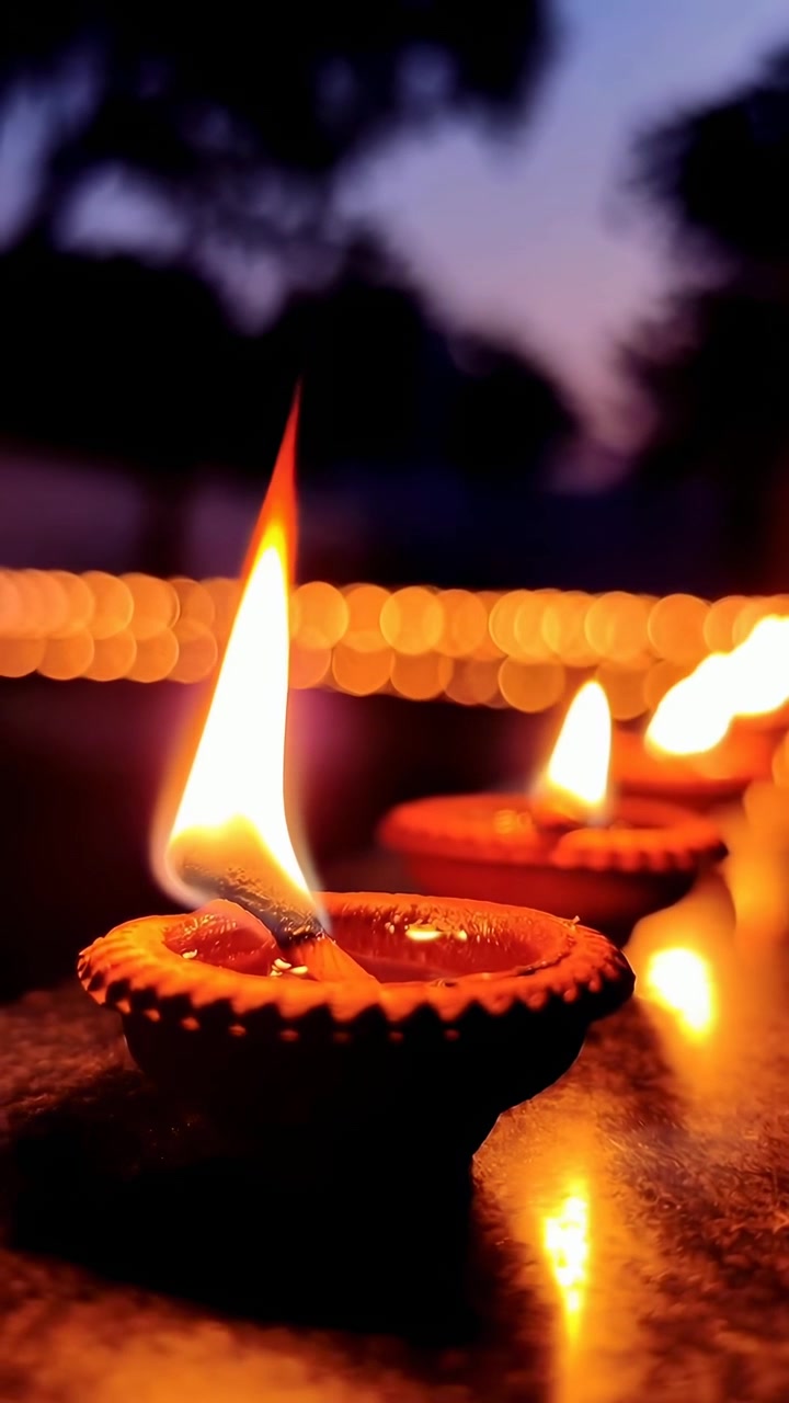 Tradizionali lampade a olio in argilla (Diyas) con fiamme tremolanti al crepuscolo