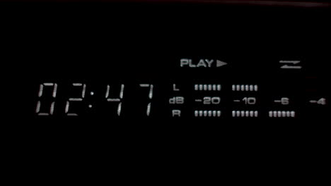 a close up shot of a digital display unit of a hi fi stereo system, the display providing a time metre and decibel reading as music is played from an old cassette