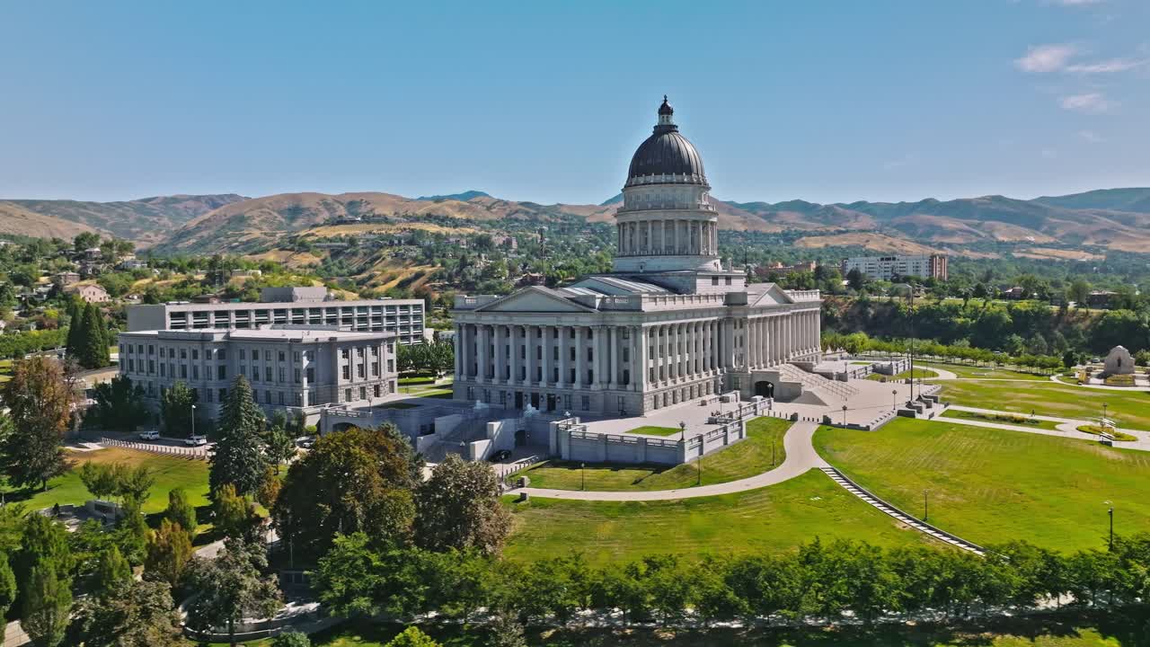 State capitol building with american flag waving, towards hillside residential