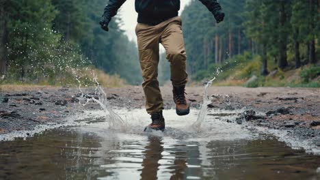 person splashing through puddles on a forest trail