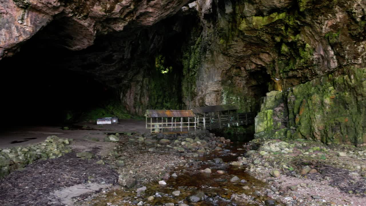 revealing the opening of Smoo Cave and walking platform leading to the waterfall