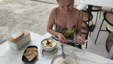 woman enjoying a delicious green curry in a cafe