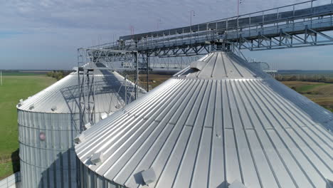 tops of grain elevators. modern silver granaries for grain storing and processing. exterior of aluminum containers at sunlight. view from the air.