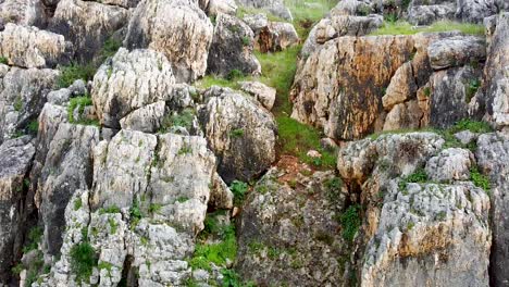 Upward-drone-shot-over-rock-cliff-reveal-the-Galilee-sea-over-the-Arbel-Cliff,Israel,-aerial-shot