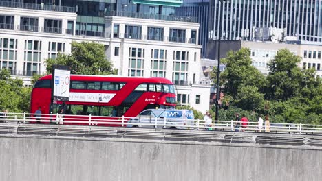 a red bus travels across a bridge