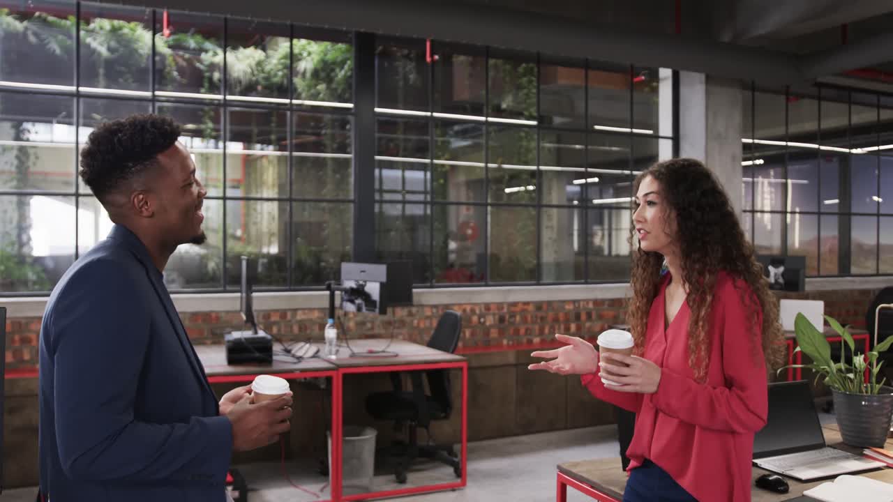 dos felices y diversos colegas creativos en discusión en una oficina casual, cámara lenta