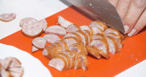 woman slicing sasuage in kitchen