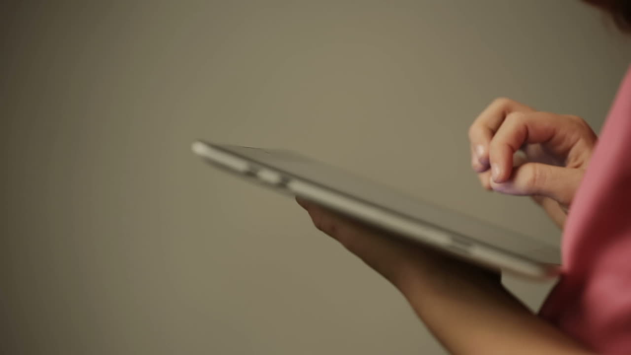 Girl with a tablet in the hands.. Kid is touching the screen of tablet device