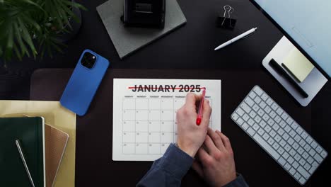 person planning january 2025 on a desk calendar