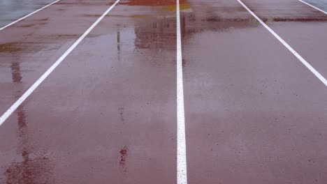 día lluvioso, pista de atletismo en el estadio. las líneas son verticales.