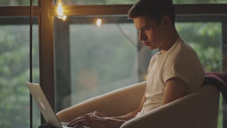 caucasian man using laptop while sitting on the couch at home
