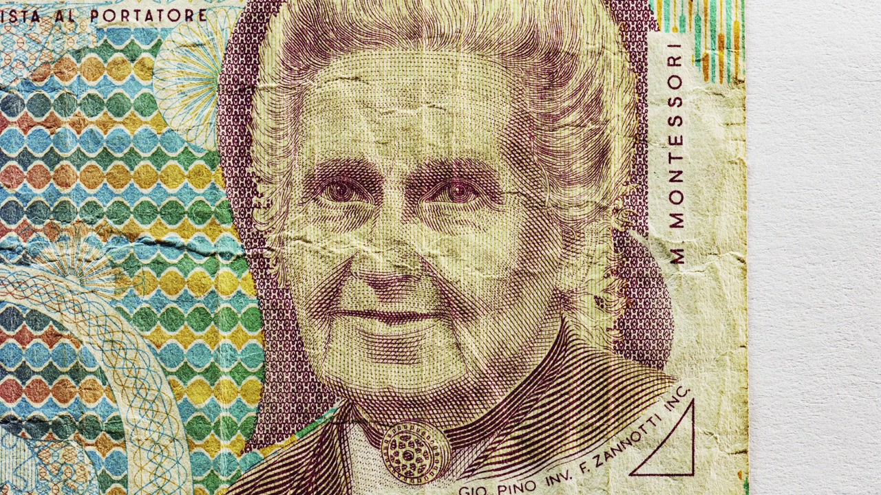 Close pan of an Italian 1000 lire note showing portrait, Italian text and deep folds