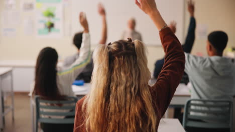 students raising hands in classroom