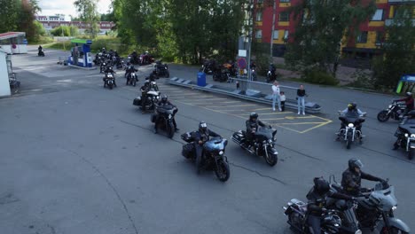 large group of bikers at gas station