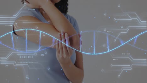 Animación-De-Diagramas-De-Redes-Y-Cadenas-De-ADN-Sobre-La-Sección-Media-De-Una-Mujer-Birracial-Sosteniendo-El-Codo.