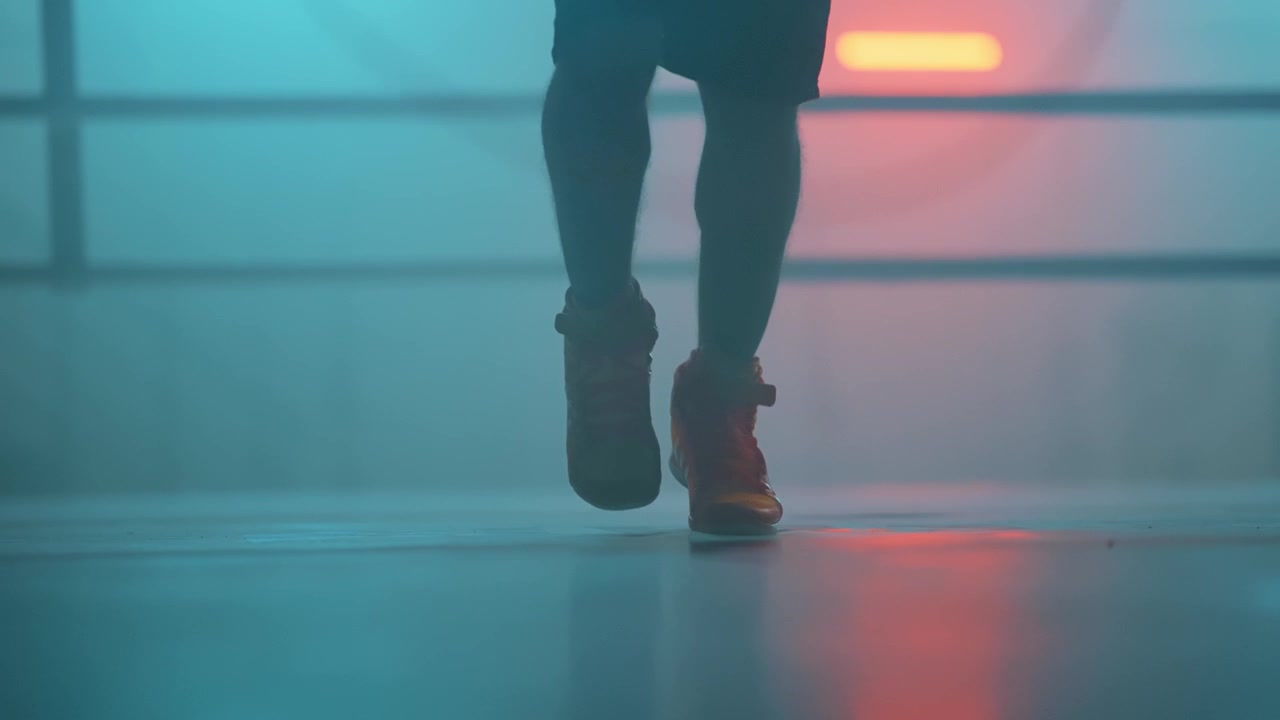 Neon ışıklı bir spor salonunda ip atlayan sporcunun ayakları