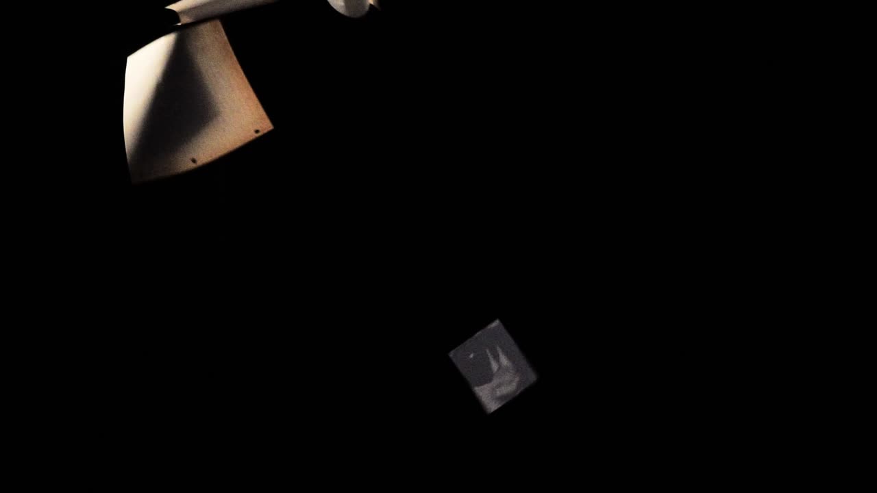 Sheets of paper are raising in slow motion on the black background