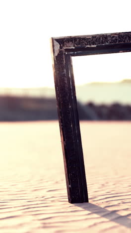 ein holzrahmen an einem strand bei sonnenuntergang