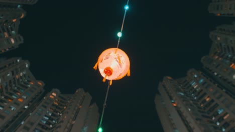 chinese lantern hanging between city buildings at night