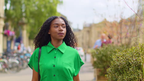 Female-Tourist-On-Vacation-In-Oxford-UK-Exploring-City-Walking-Along-Broad-Street