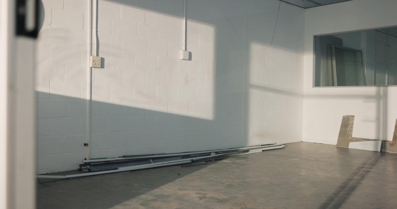 Sunlight Moving Across White Brick Wall in Empty Industrial Space