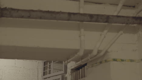 Rustic-pipes-run-along-a-white-ceiling,-showing-signs-of-age-and-corrosion