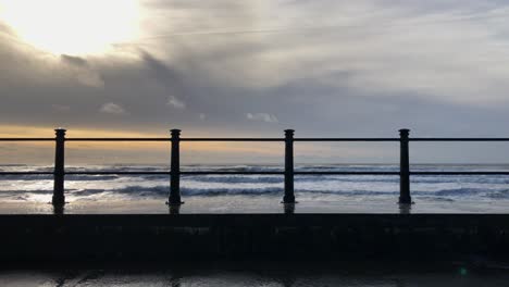 morning ocean waves crash, splash over seawall in tramore, ireland