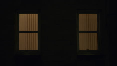 two windows with reflection of car passing, at night in city